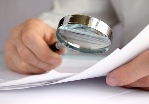 Medewerker bekijkt rapport met vergrootglas