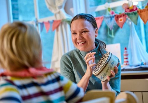 Pedagogisch medewerker speelt met peuter