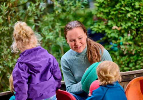 Pedagogisch medewerker buiten met kinderen