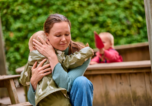 medewerker knuffelt kind