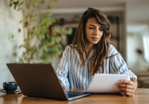 medewerker kijkt naar papieren en laptop