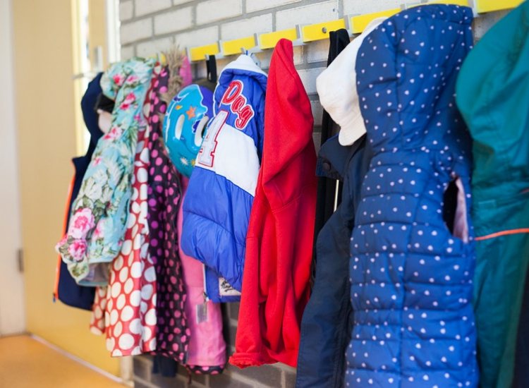 kinderjasjes hangen aan de kapstok bij een kinderopvanglocatie