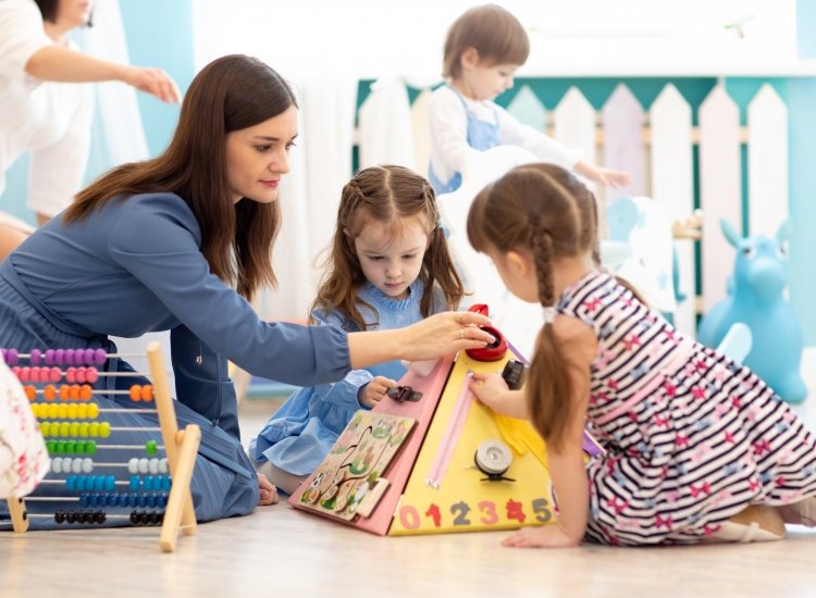 Spelende kinderen met begeleider in kinderopvang