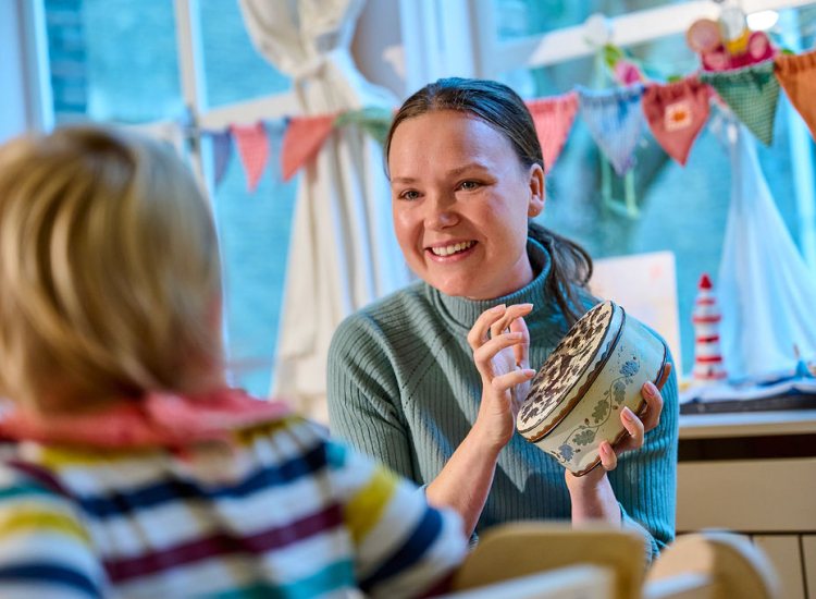 Pedagogisch medewerker speelt met peuter
