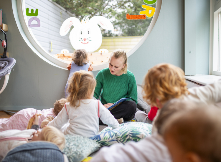 medewerker leest voor aan kinderen