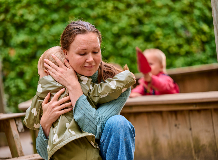 medewerker knuffelt kind