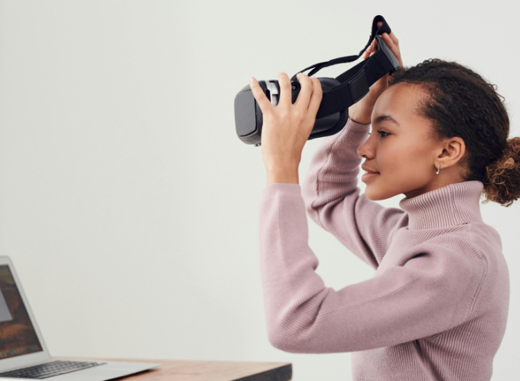 Vrouw achter laptop met vr-bril