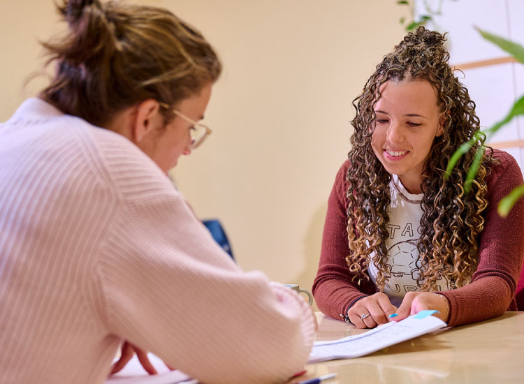 Twee vrouwen aan tafel bespreken een document