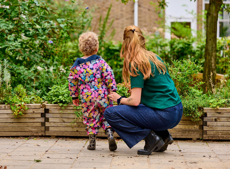 Pedagogisch medewerker met kindje buiten