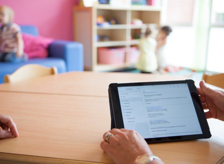 Pedagogisch medewerker bekijkt iPad.